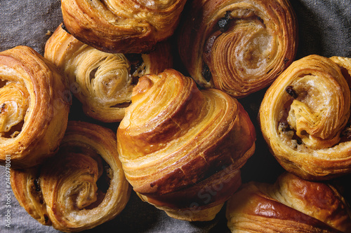 Canvas Print Variety of homemade puff pastry buns cinnamon rolls and croissant over grey cloth