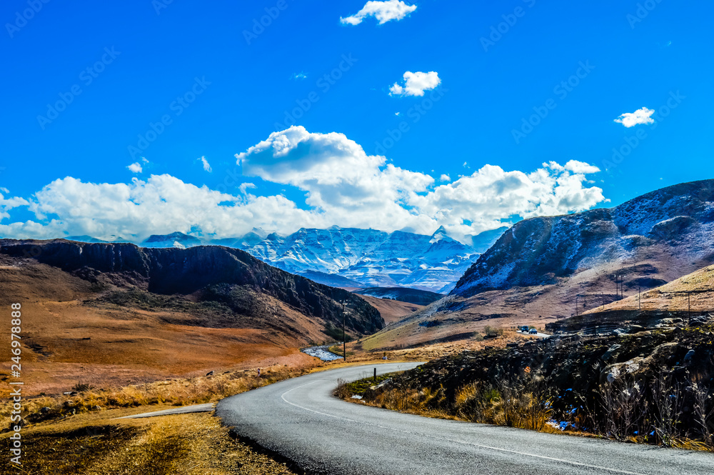 Snow landscape in Drakensberg mountains in Underberg South Africa under blue sky and flakey clouds Snow landscape in Drakensberg mountains in Underberg South Africa under blue sky and flakey clouds