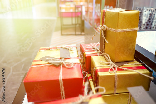 present gift in with red - gold wrapping paper and raw rope bow decoration.