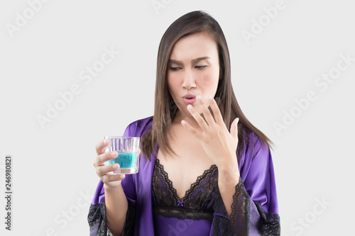 Woman in sexy silk nightgown and purple robe feel burn in her mouth because using mouthwash photo