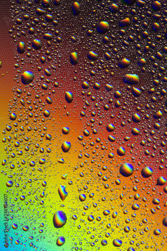 Drops of water on the glass  with the reflection of the rainbow.