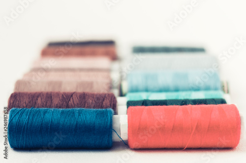 Colored sewing thread coils on white background with copy space for text. photo