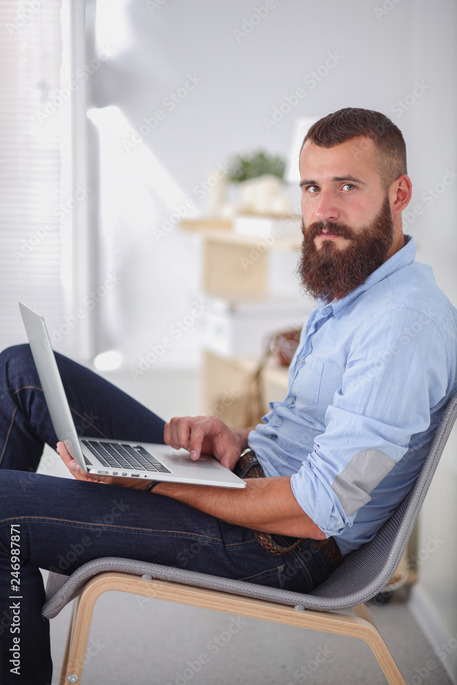 Young businessman sitting on chair in office Young businessman sitting on chair in office