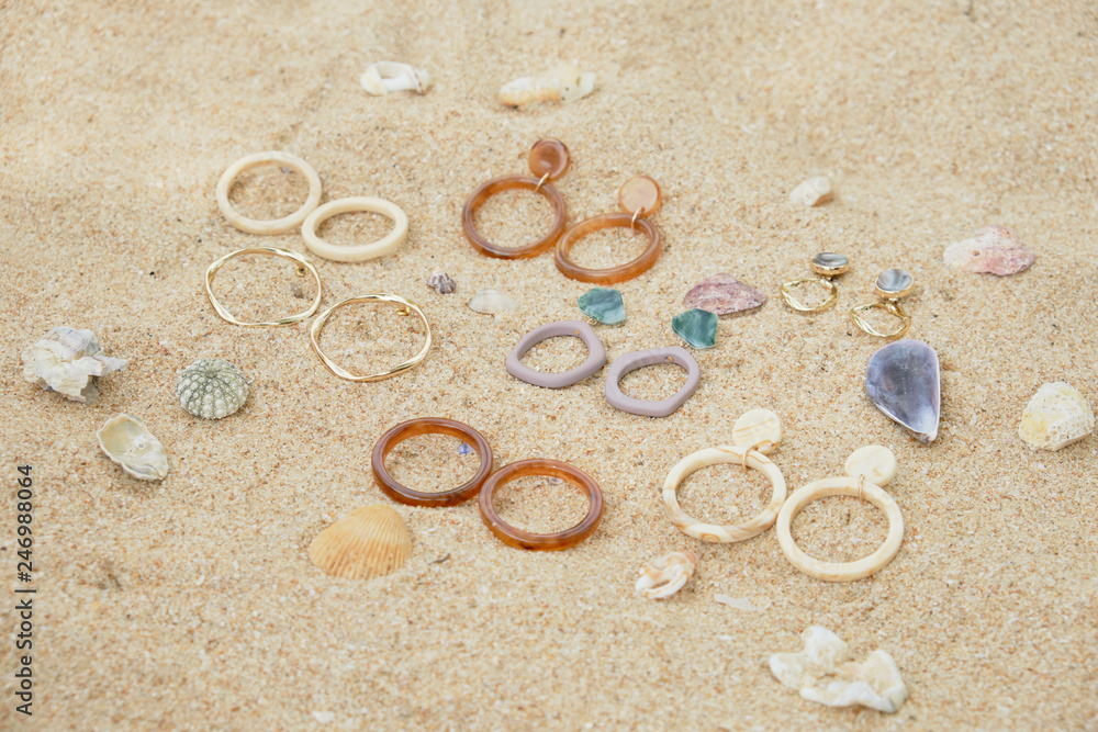 Handmade Jewelry on Sand Beach Top Down View. Travel Cheap Jewels Souvenir on Sea Shell Background. Craft Summer Earring and Stone Ring for Fashion Gift. Aquamarine Beautiful Decoration Set Handmade Jewelry on Sand Beach Top Down View. Travel Cheap Jewels Souvenir on Sea Shell Background. Craft Summer Earring and Stone Ring for Fashion Gift. Aquamarine Beautiful Decoration Set