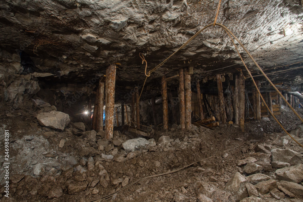 Underground gold ore emerald mine shaft tunnel gallery passage with wooden stands timbering Underground gold ore emerald mine shaft tunnel gallery passage with wooden stands timbering