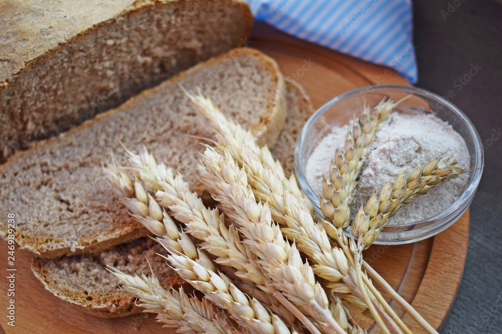 Healthy bread made of whole wheat flour and ears on a wooden Board.