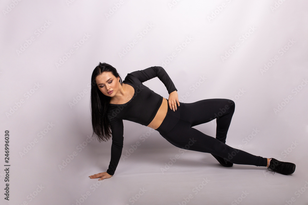 Fitness woman doing the exercise. Sport woman in sport style clothes on floor doing the exercise
