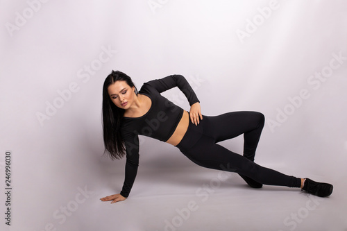 Fitness woman doing the exercise. Sport woman in sport style clothes on floor doing the exercise