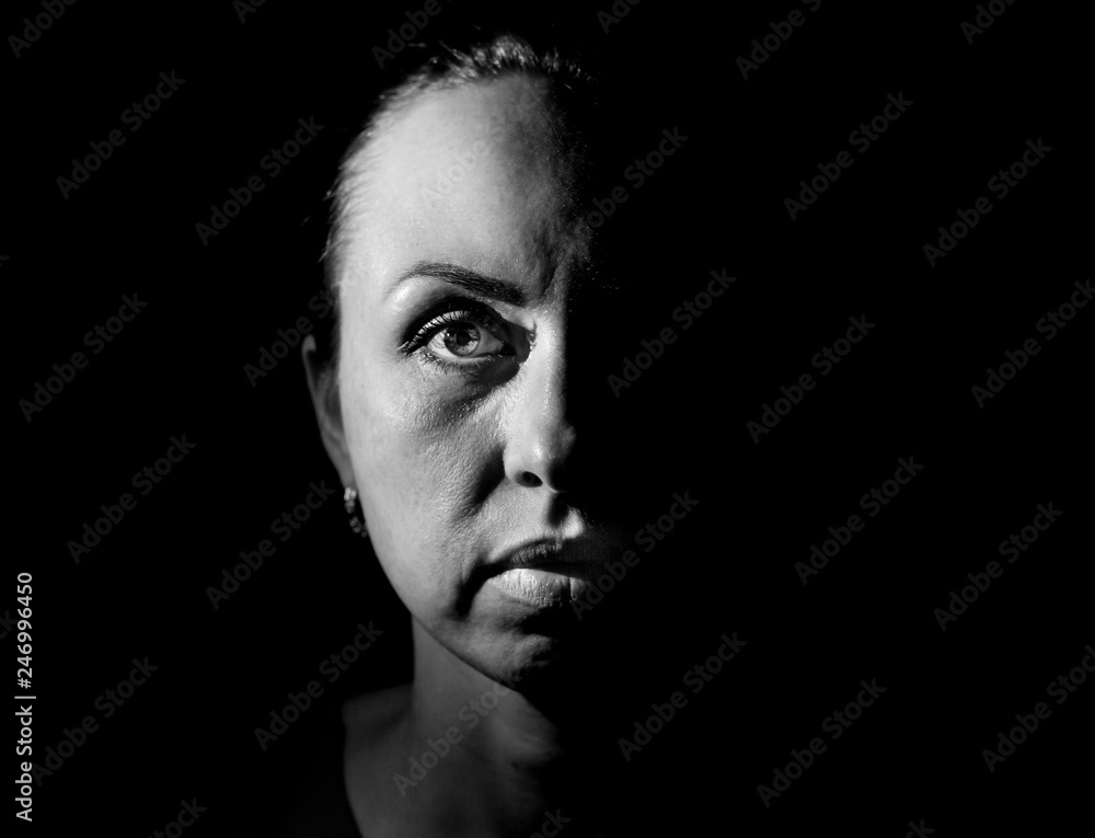 Stylish portrait of a attractive calm caucasian woman. Black and white shot, low-key lighting. Isolated on black.