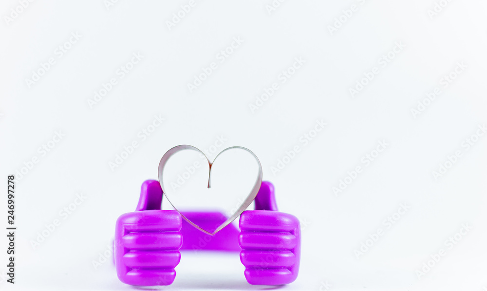 Ribbons shaped as hearts on top plastic hand on white background, valentine day concept