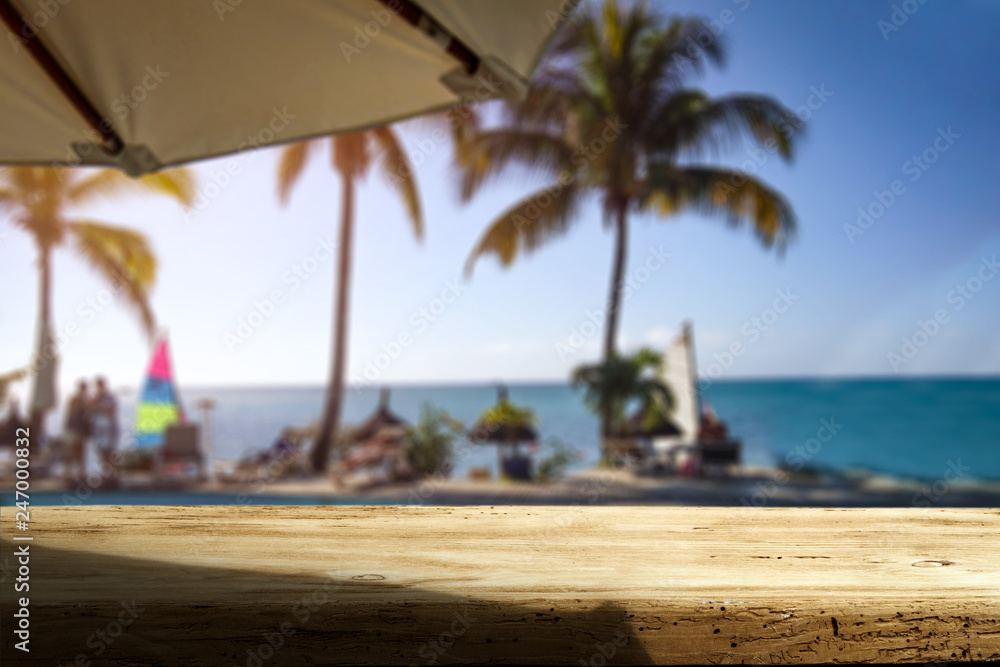 Fototapeta premium Wooden desk of free space and exotic landscape of sea and palms