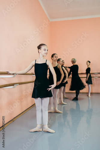 Choreographed dance by a group of beautiful young ballerinas practicing during class at a classical ballet school.