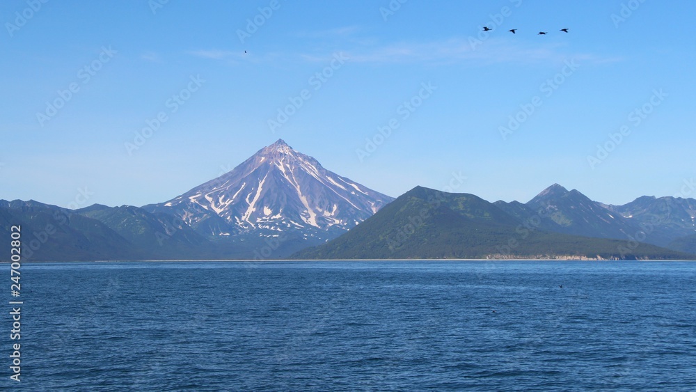 View of Vilyuchinsky volcano (also called Vilyuchik) from tourist boat. It's a stratovolcano in the southern part of Kamchatka Peninsula, Russia. View of Vilyuchinsky volcano (also called Vilyuchik) from tourist boat. It's a stratovolcano in the southern part of Kamchatka Peninsula, Russia.