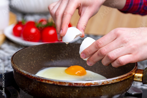 Frying homemade, chicken eggs in the frying pan for a healthy breakfast. Protein food