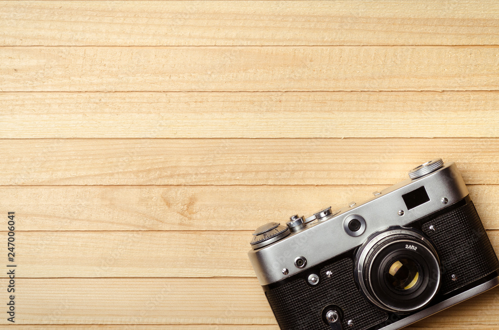 old vintage film camera on wooden background, top view
