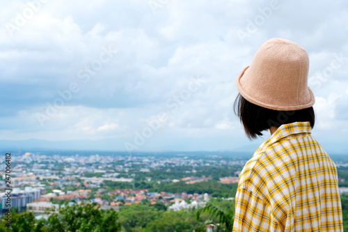 Back of young asian girl traveler standing in city and outdoors nature view background, travel spring, summer holiday vacation concept, gen Z © mangpor2004