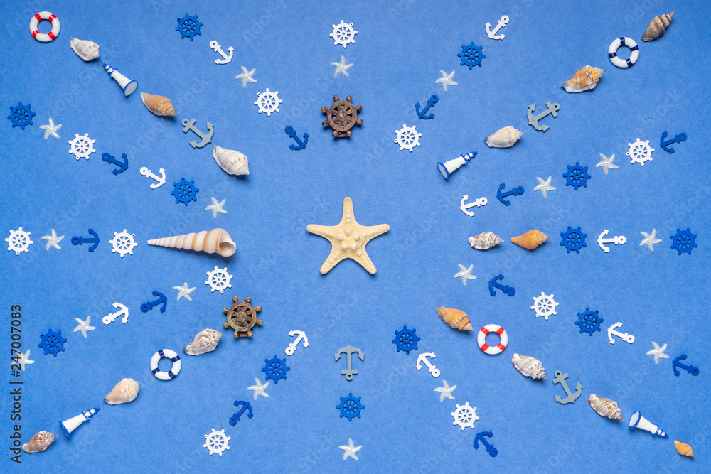 Sun symbol made of decorative items and miniature toys: seashells, seastars, anchors, steering wheels, life buoys, lighthouses. Creative composition with starfish. Summer vacation, sea travel concept