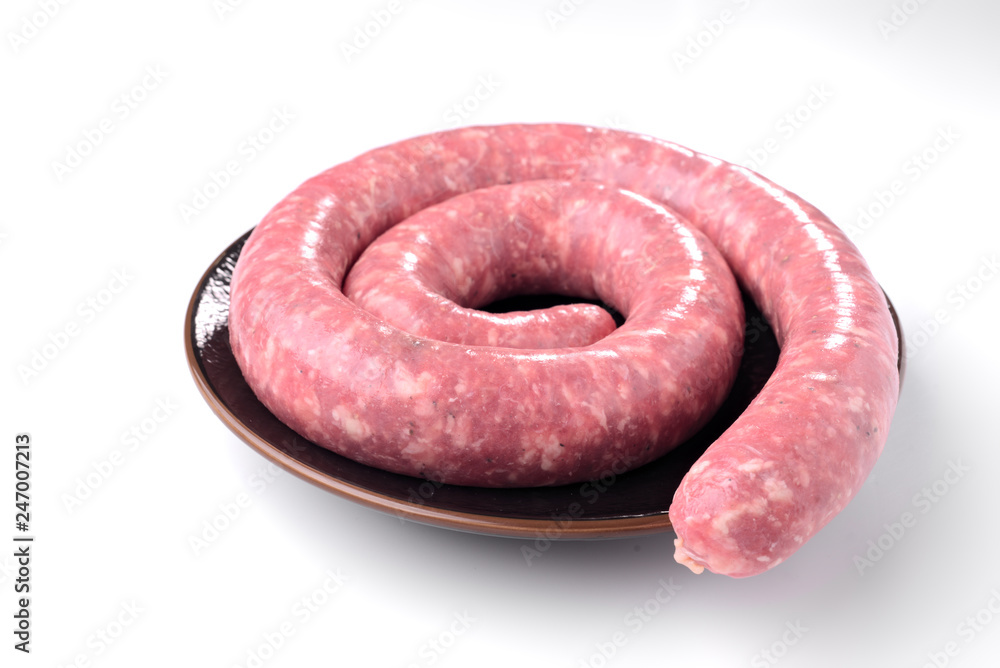 spiral of Catalan sausage on brown porcelain plate isolated on white background spiral of Catalan sausage on brown porcelain plate isolated on white background