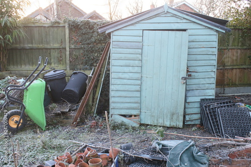 Cuadro en lienzo Winter landscape of wooden decaying old shed in allotment garden with raised bed