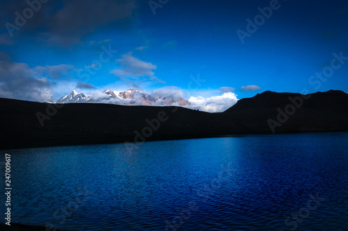 Snow capped mountains reflecting in the Chandrataal Lake at sunrise 