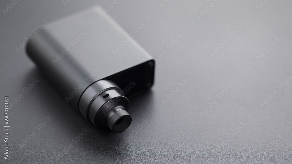 high end rebuildable dripping atomizer with black regulated box mods on black texture background, vaping device, selective focus with shallow depth of field high end rebuildable dripping atomizer with black regulated box mods on black texture background, vaping device, selective focus with shallow depth of field