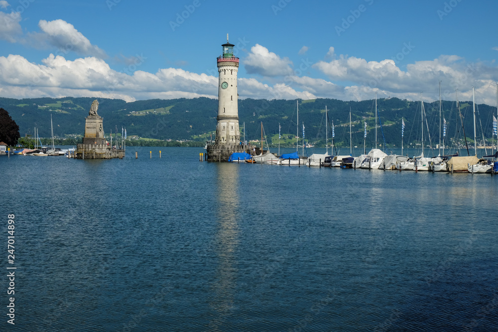 a large monument as entrance to the harbor of lindau on lake constance
