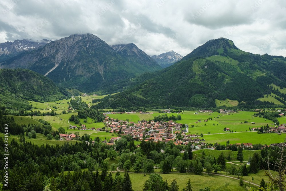 idyllic mountain landscape with a small village and mountains in the background