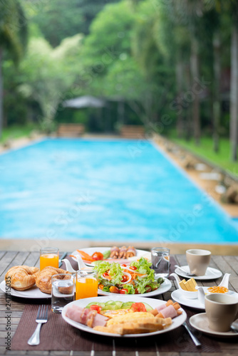 Food series: American breakfast set on wooden table by the pool