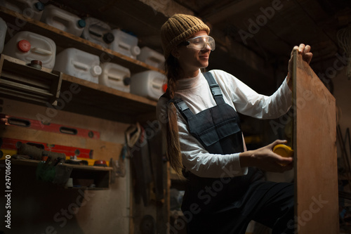 Portrait of smiling young girl carpenters in workshop room
