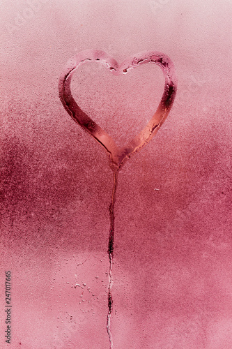 Figure heart on the glass. The texture of misted glass. Drops on the glass. Bright pink color picture. Valentine's Day