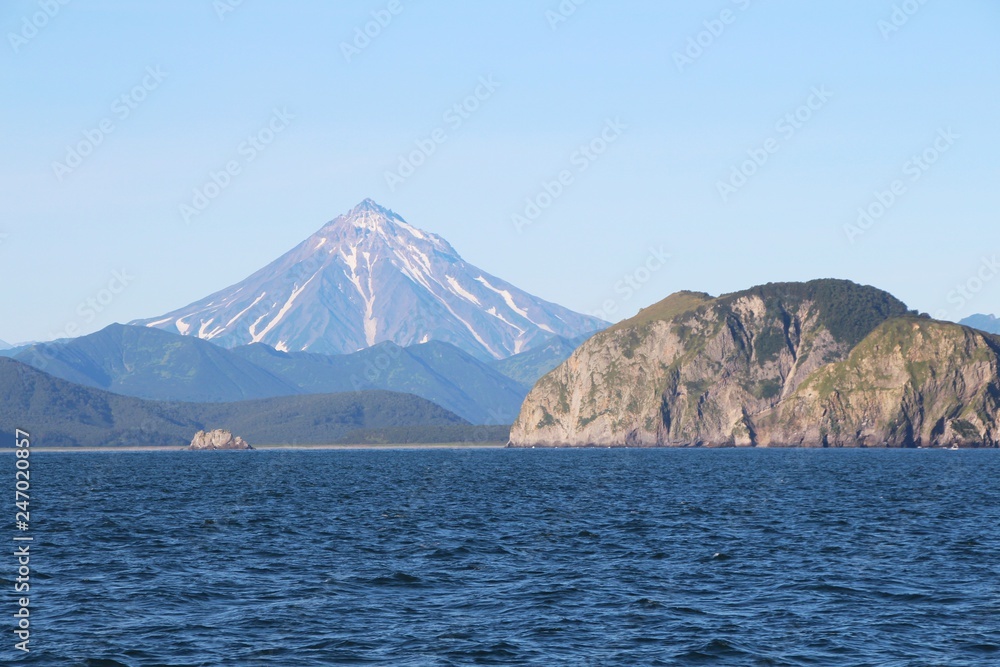 View of Vilyuchinsky volcano (also called Vilyuchik) from tourist boat. It's a stratovolcano in the southern part of Kamchatka Peninsula, Russia. View of Vilyuchinsky volcano (also called Vilyuchik) from tourist boat. It's a stratovolcano in the southern part of Kamchatka Peninsula, Russia.