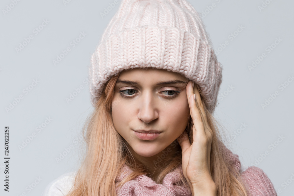 Close up studio portrait of young girl in a pink sweater and white hat deep in thought, lost in thought/ doubts, pensive woman, trying to remember something important, makes choice, emotions concept. Close up studio portrait of young girl in a pink sweater and white hat deep in thought, lost in thought/ doubts, pensive woman, trying to remember something important, makes choice, emotions concept.