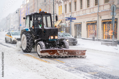 a tractor clean street from snow after a blizzard b
