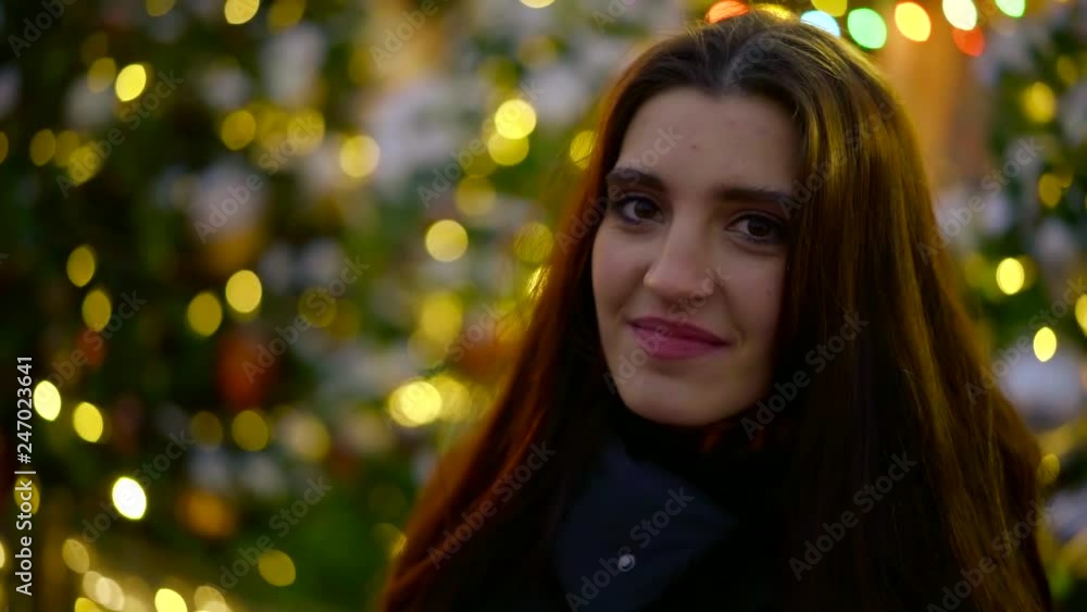 brunette girl is looking at camera in Christmas time outdoors,meeting her boyfriend and kissing him brunette girl is looking at camera in Christmas time outdoors,meeting her boyfriend and kissing him
