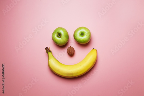 banana and apples smiley on pink fashion background with space for text