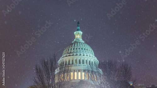 Snow flakes fall over the United States Capitol Building dome as a snowstorm passes through the Washington, D.C. area