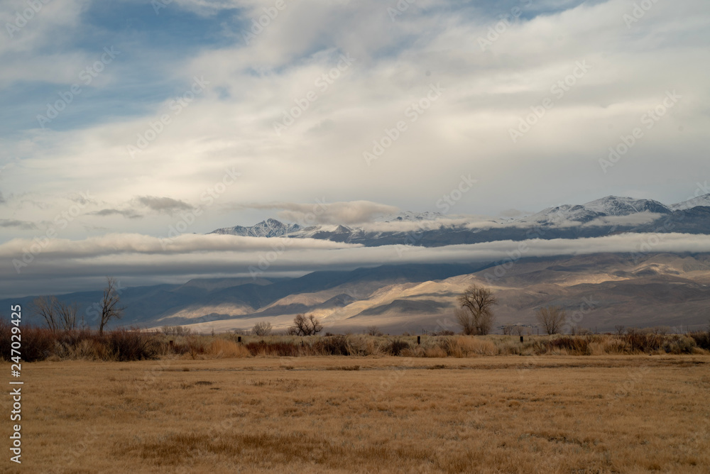 cloud covered mountain range in desert valley landscape