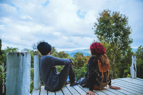 couple lover natural travel on the mountain, sitting relax reading books in the midst of nature on the white wooden bridge. photo