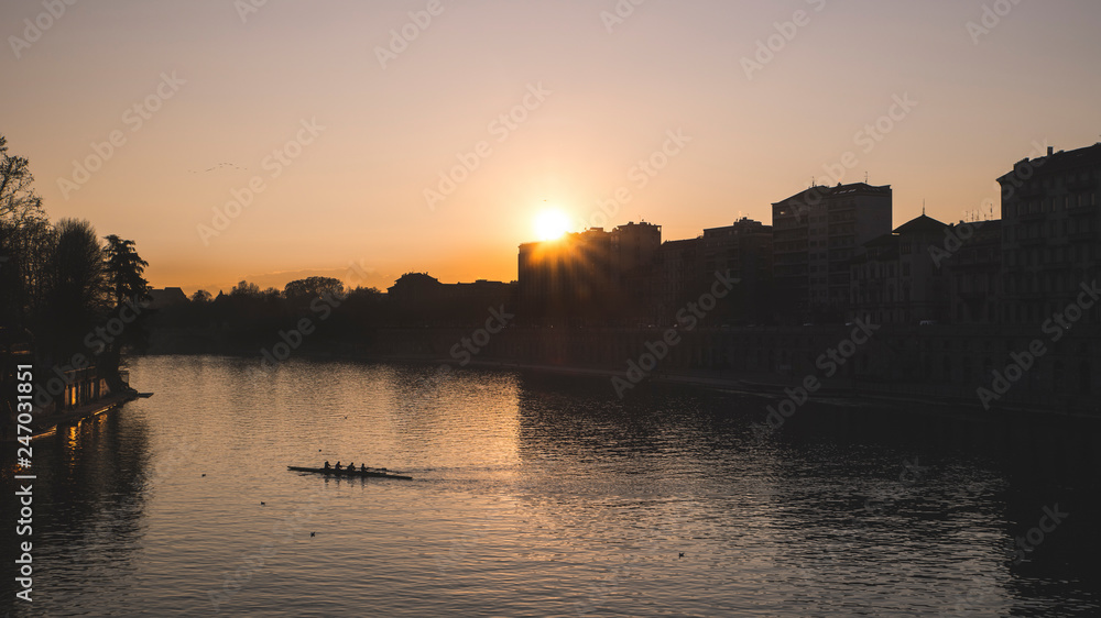 Sunset on the river Po in the city of Turin with rowing boat.