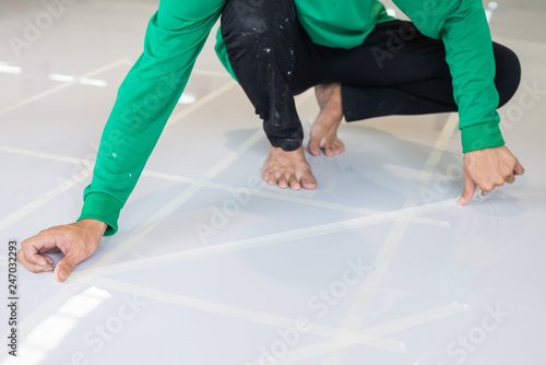 Construction series: Worker painting direction on epoxy floor