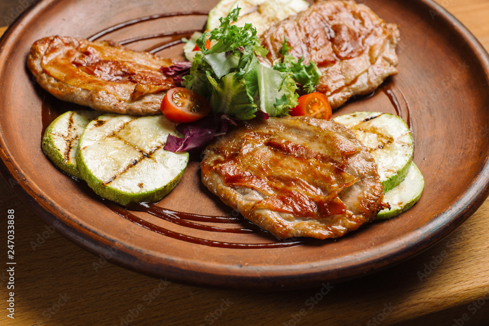 Grilled chicken breast with vegetables on clay plate. Grilled chicken breast with vegetables on clay plate.