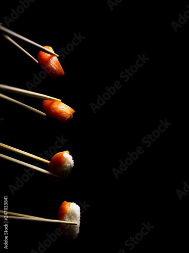 Japanese food. Minimalism. Food Photos. Pieces of sushi with wooden chopsticks.