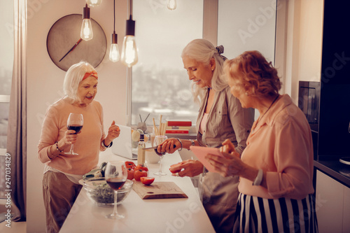 Joyful aged woman giving advice to her friends