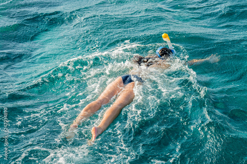 Young woman snorkeling in transparent shallow. Young woman at snorkeling in the tropical water. active woman free diving snorkeling in beautiful blue ocean on summer vacation.