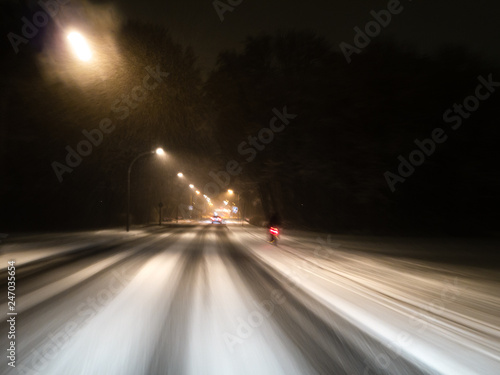 Motion Blur: Driving fast on a snowy street with street lights at night