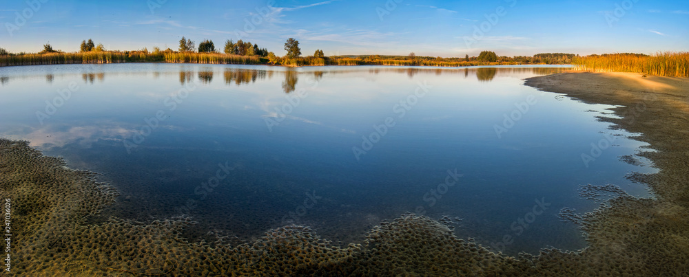 panoramic view on Lake with vegetation on the sandy shore
