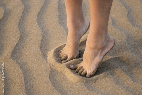 Detail of female legs on golden sea sand of the beach close up. Pleasant sensation © Anna Sitnik