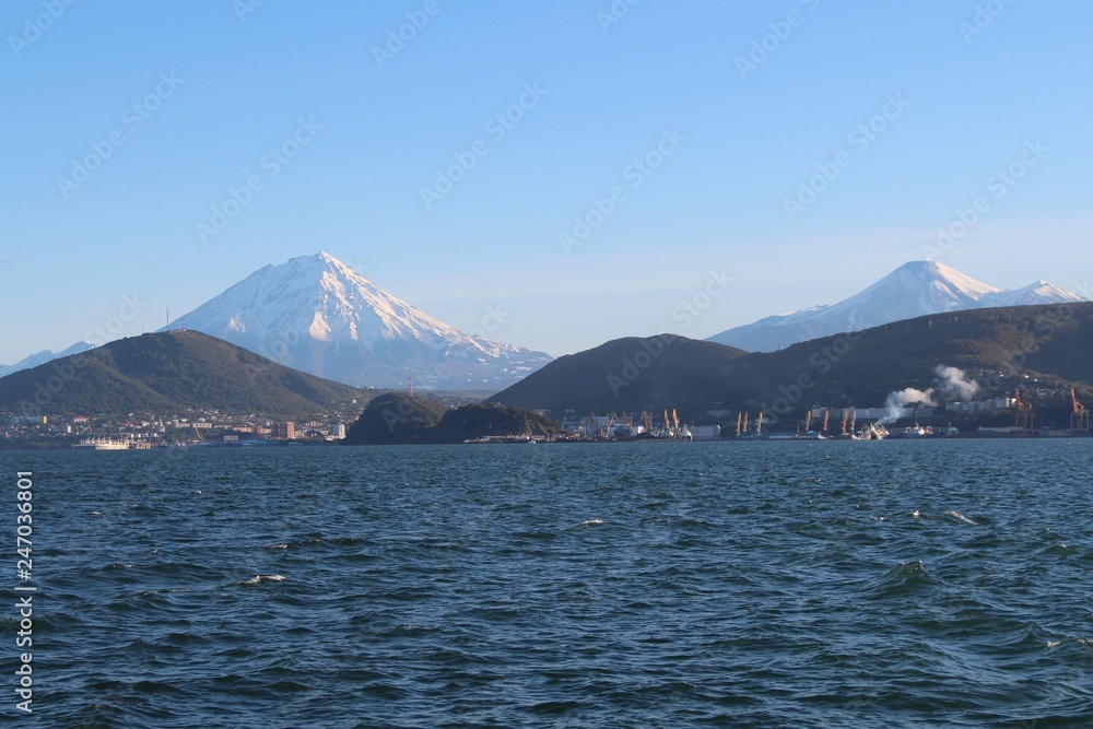 Avachinsky and Koryaksky volcanoes towers over the city of Petropavlovsk-Kamchatsky on the Kamchatka Peninsula, Russia. Avachinsky and Koryaksky volcanoes towers over the city of Petropavlovsk-Kamchatsky on the Kamchatka Peninsula, Russia.