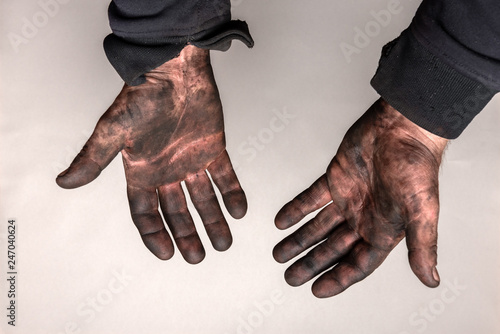 Dirty hands in car masut (black oil) on gray background. photo