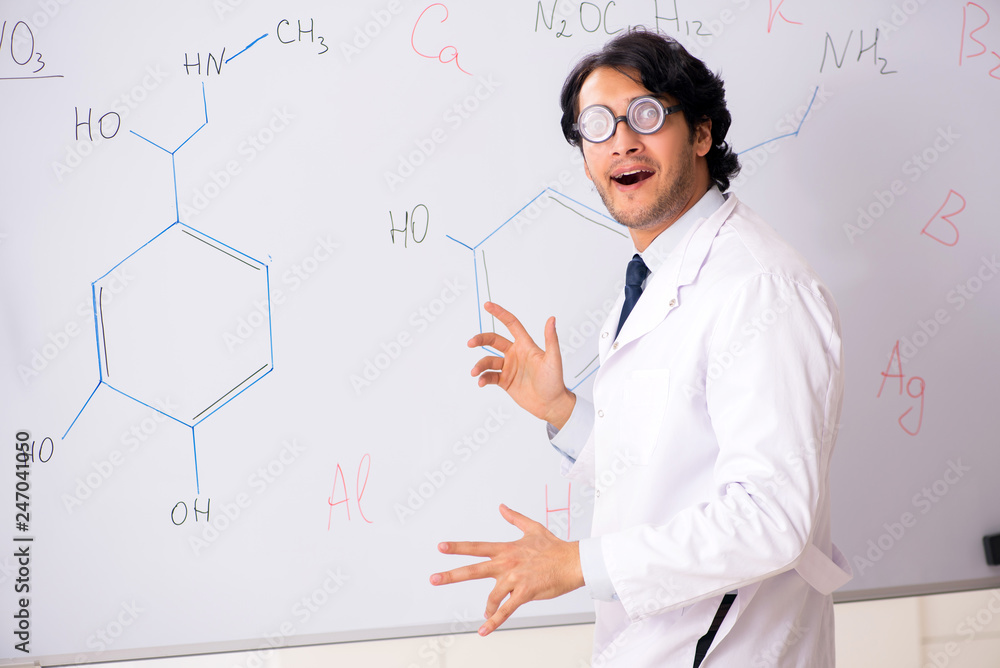 Young funny chemist in front of white board Young funny chemist in front of white board